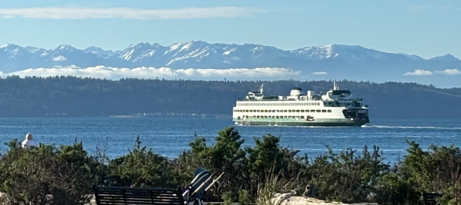 Car feerry on the PUget Soound on a beauticcul clear day with snowy mountains in the background.